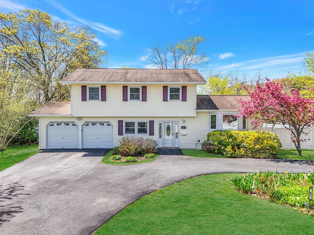 67 Landscape Dr, Wheatley Heights, NY 11798 - colonial house with roof with shingles, a front yard, and aphalt driveway