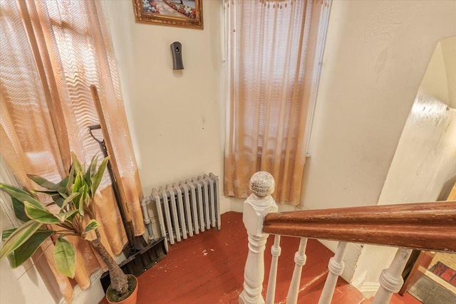 stairs with radiator heating unit and wood finished floors