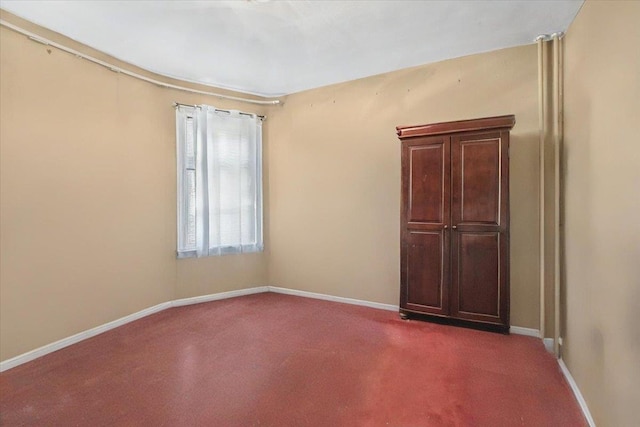 carpeted spare room featuring baseboards