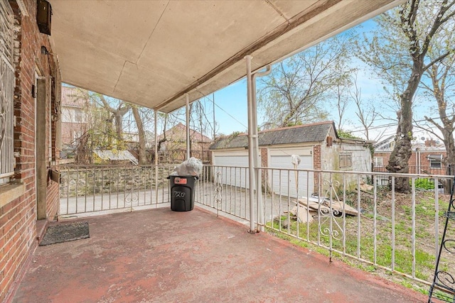 view of patio with a garage and an outbuilding