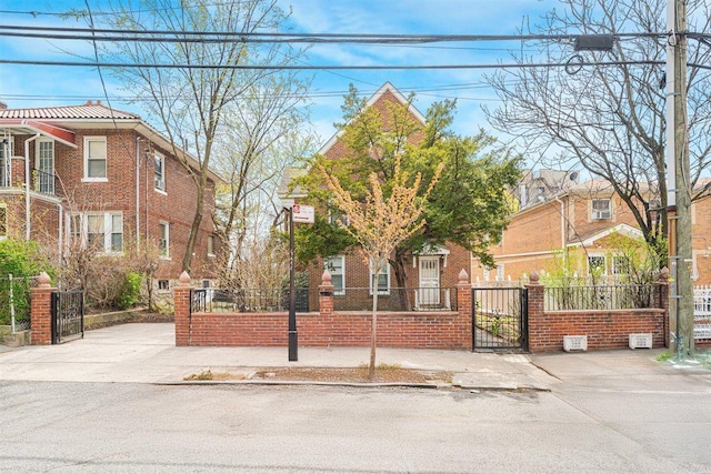 view of front of home featuring brick siding, a gate, and a fenced front yard