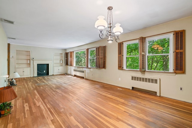 65 Preston St, Huntington, NY 11743 - unfurnished living room featuring radiator, hardwood / wood-style floors, and a chandelier