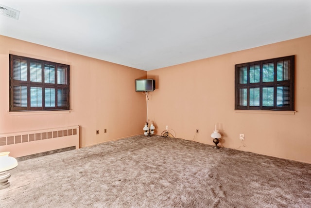 65 Preston St, Huntington, NY 11743 - spare room with radiator, carpet flooring, and healthy amount of natural light