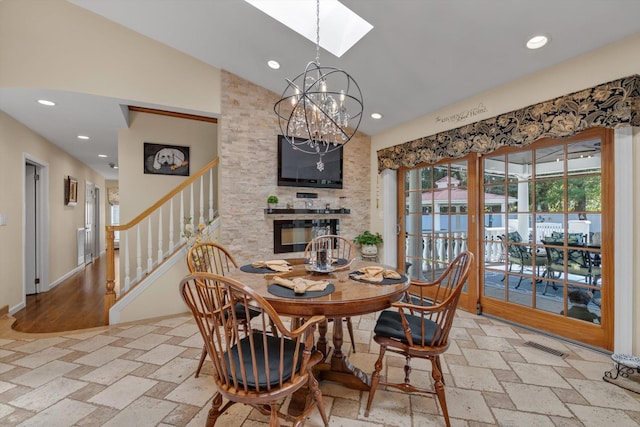 dining space with a notable chandelier, vaulted ceiling with skylight, stairs, recessed lighting, and visible vents