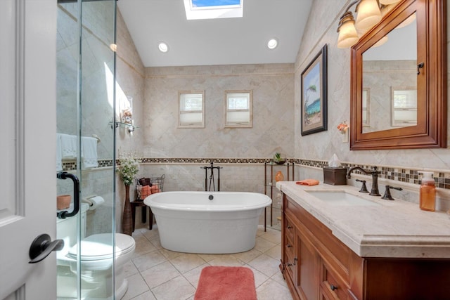 full bath with vanity, tile patterned floors, a freestanding tub, tile walls, and a stall shower
