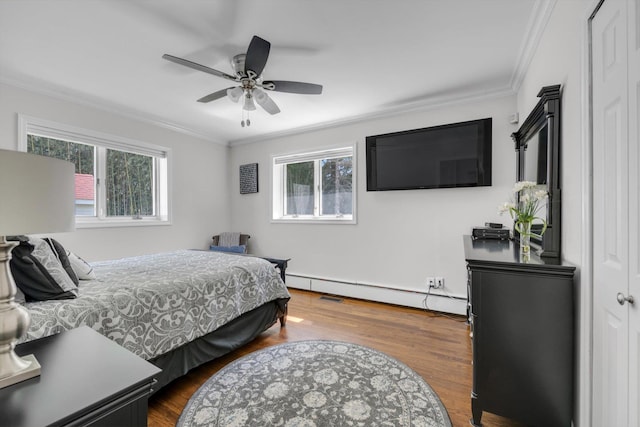 bedroom featuring dark wood-type flooring, ornamental molding, and baseboard heating