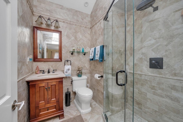 bathroom with tile walls, a stall shower, vanity, tile patterned floors, and toilet