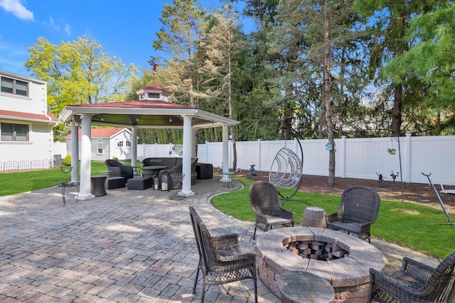 view of patio / terrace featuring a fenced backyard, an outdoor living space with a fire pit, an outdoor structure, and a gazebo