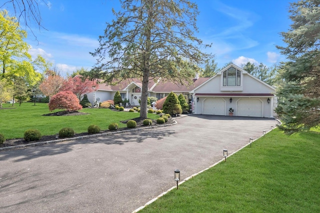 view of front of home featuring stucco siding, a garage, driveway, and a front lawn