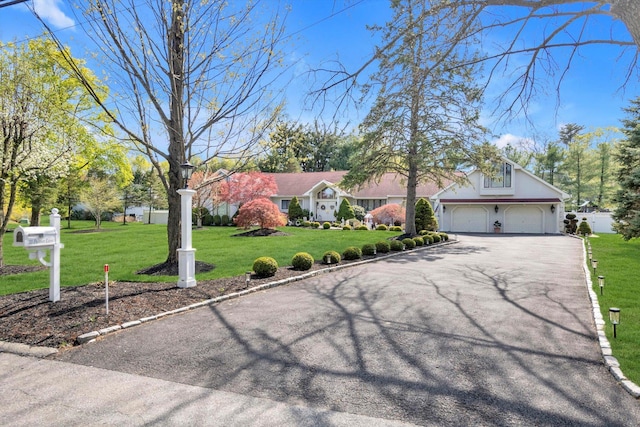 ranch-style house with an attached garage, driveway, and a front yard