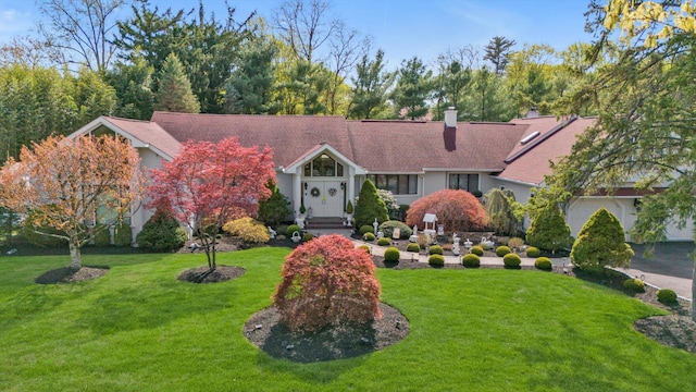 view of front of house featuring a chimney and a front yard