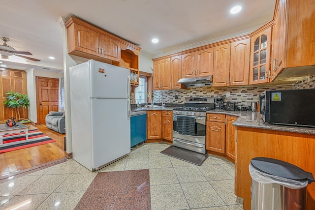 kitchen with black microwave, dishwasher, gas stove, ventilation hood, and freestanding refrigerator