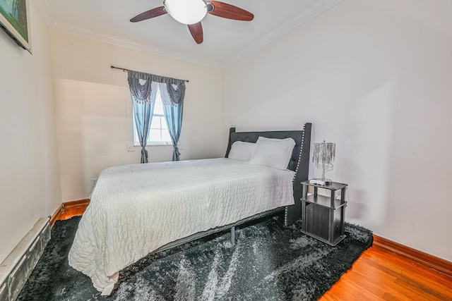 bedroom featuring ceiling fan, ornamental molding, baseboard heating, and wood finished floors