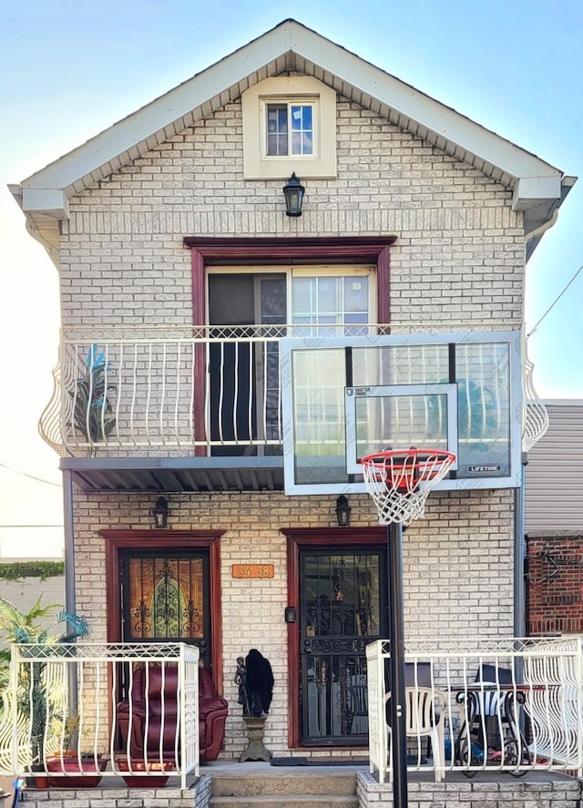 3438 12th St, Astoria, NY 11106 - property entrance with a balcony, brick siding, and covered porch