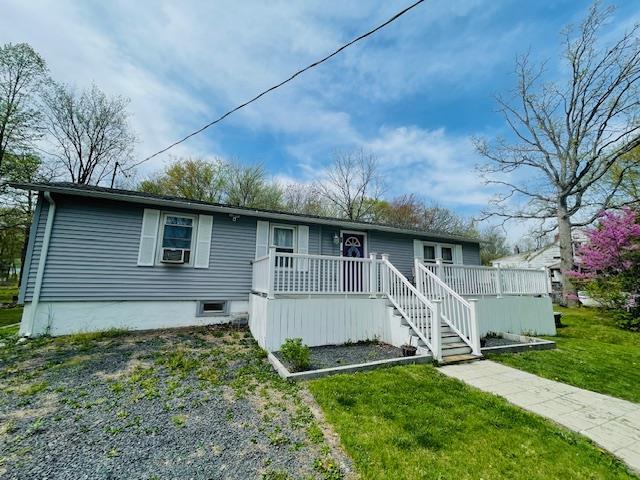 single story home featuring cooling unit and a front yard