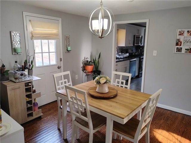 dining area featuring baseboards, a notable chandelier, and dark wood finished floors