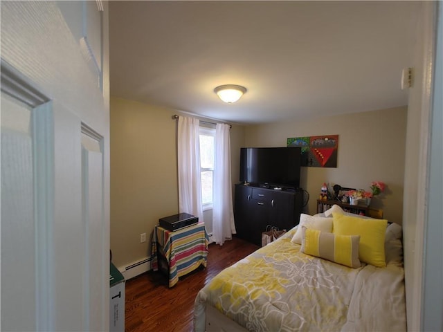 bedroom with dark wood-style flooring and a baseboard heating unit