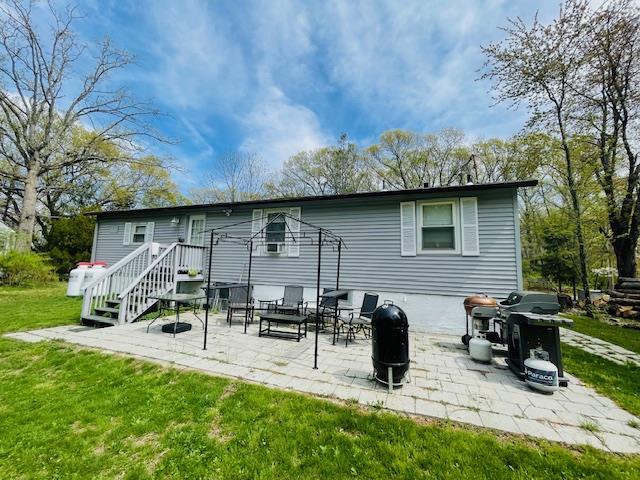 back of house featuring a patio and a lawn