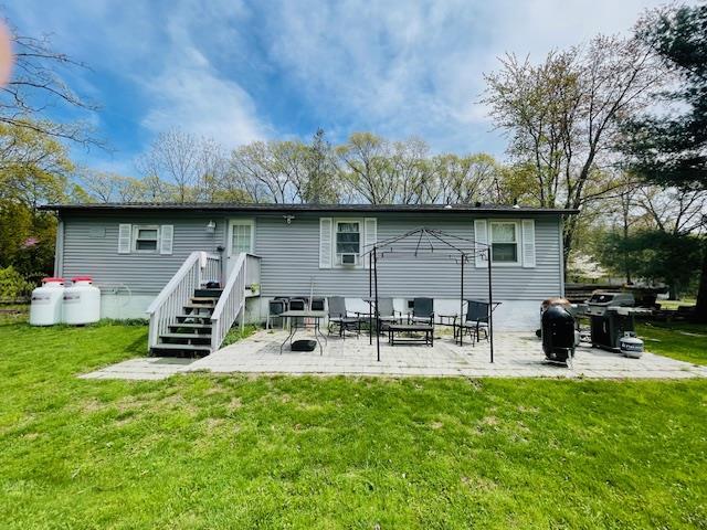 back of property featuring a lawn, an outdoor hangout area, and a patio area