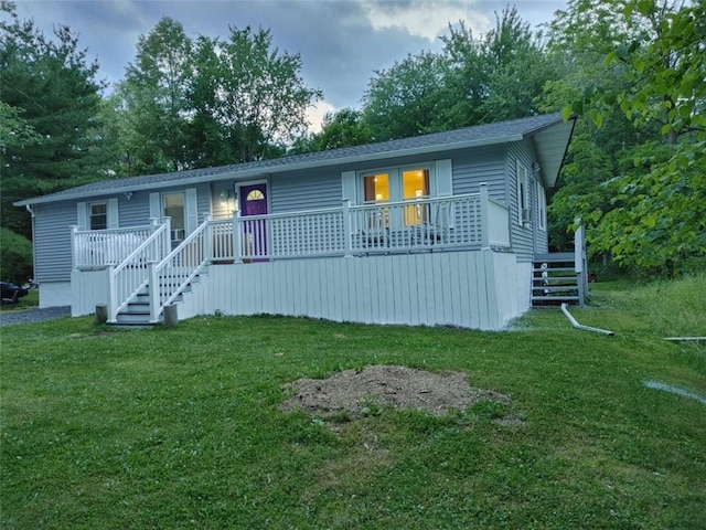 view of front of home with stairway, a shingled roof, and a front yard