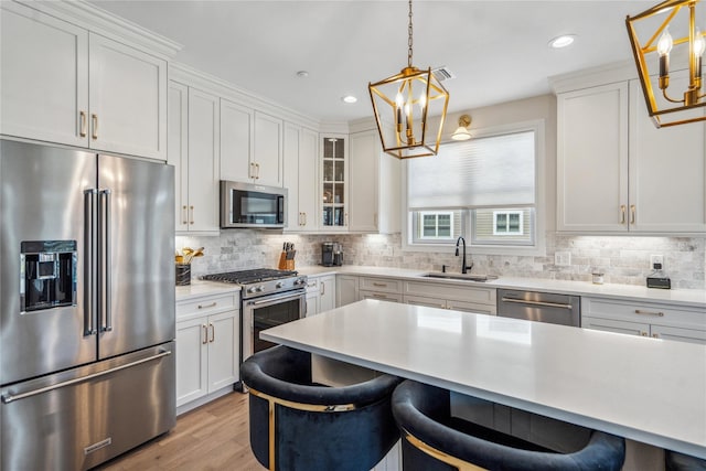20105 Aspenwood Dr, Plainview, NY 11803 - kitchen with appliances with stainless steel finishes, a chandelier, a sink, a breakfast bar, and recessed lighting