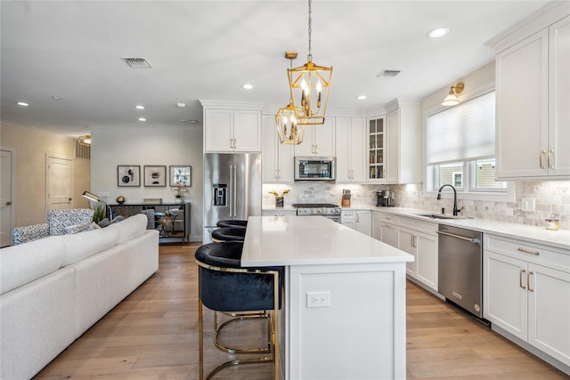 20105 Aspenwood Dr, Plainview, NY 11803 - kitchen featuring stainless steel appliances, a sink, open floor plan, a breakfast bar, and tasteful backsplash