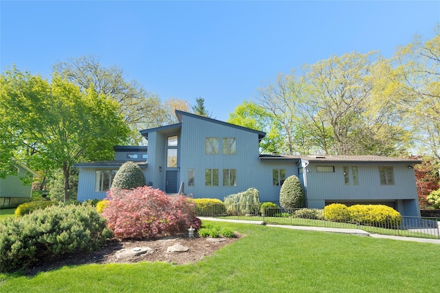 mid-century home featuring fence and a front yard