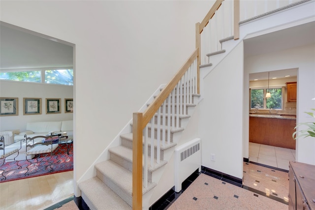 stairway with baseboards and radiator heating unit