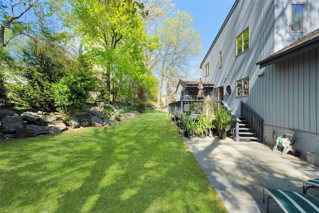 view of yard featuring a wooden deck, a patio area, and stairway