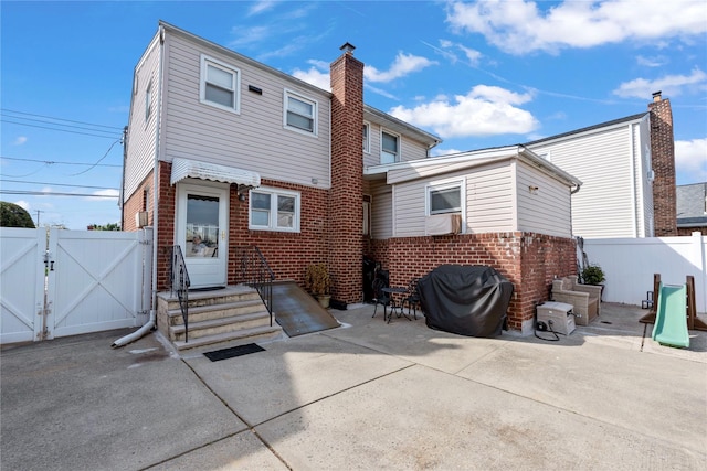 487 Emerson Pl, Valley Stream, NY 11580 - rear view of house with a gate, a patio area, brick siding, fence, and entry steps