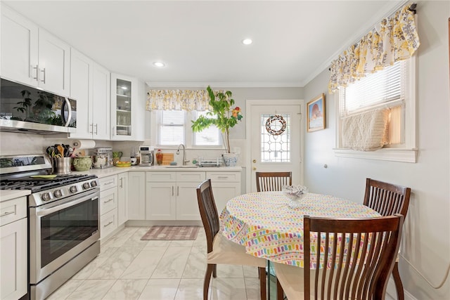487 Emerson Pl, Valley Stream, NY 11580 - kitchen with appliances with stainless steel finishes, a sink, light countertops, glass insert cabinets, and ornamental molding