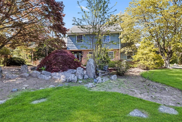 view of front of house featuring brick siding and a front lawn