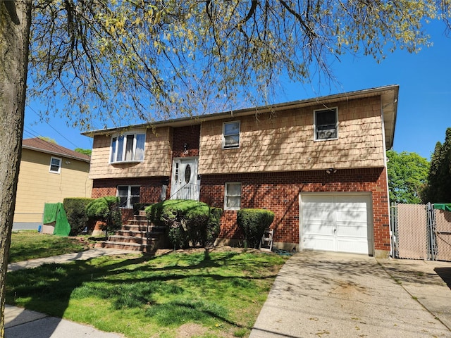 bi-level home with brick siding, driveway, a front lawn, and a garage