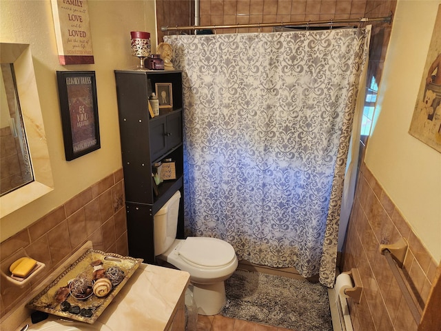 full bath with a baseboard heating unit, toilet, tile walls, and a wainscoted wall