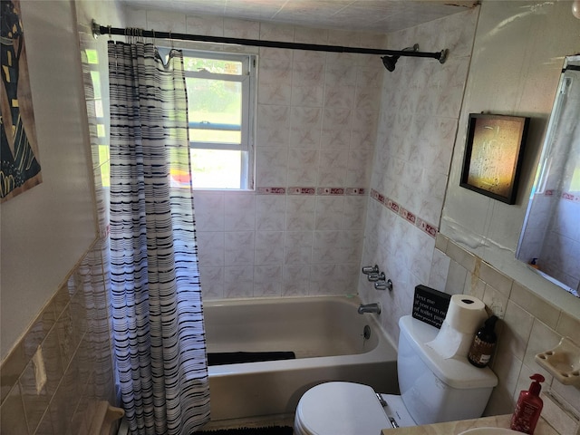 full bathroom with toilet, shower / tub combo, and tile walls
