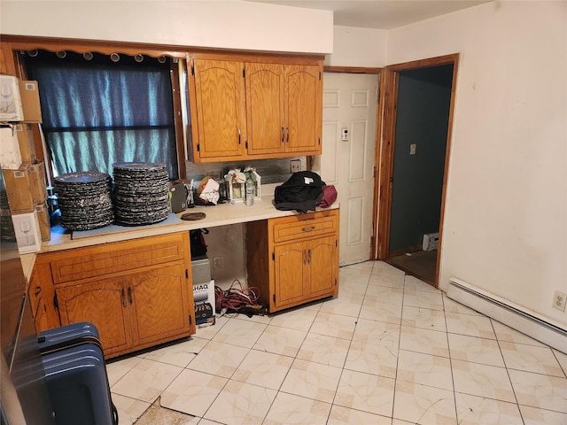 kitchen with light countertops, a baseboard radiator, and brown cabinets