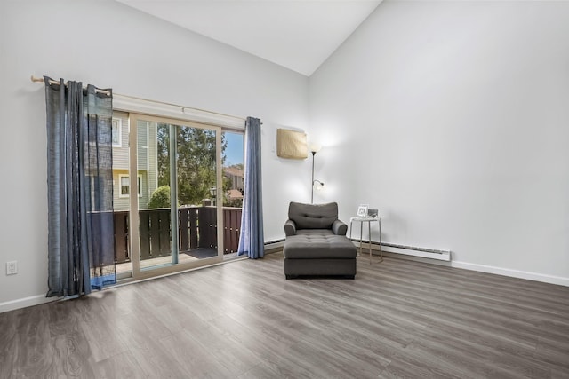 sitting room featuring high vaulted ceiling, baseboards, baseboard heating, and wood finished floors