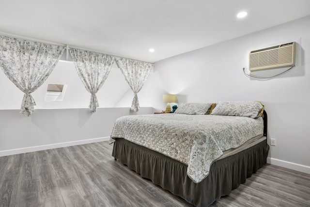 bedroom featuring recessed lighting, baseboards, a wall mounted AC, and wood finished floors