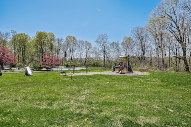 exterior space with a swimming pool, a yard, and playground community