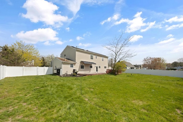 rear view of property with a yard and a fenced backyard