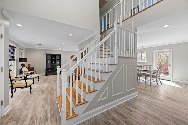 stairs with crown molding, baseboards, recessed lighting, and wood finished floors