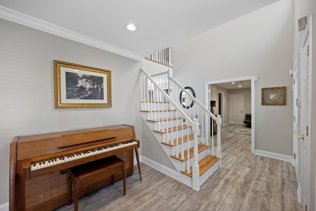 stairway with recessed lighting, baseboards, and wood finished floors