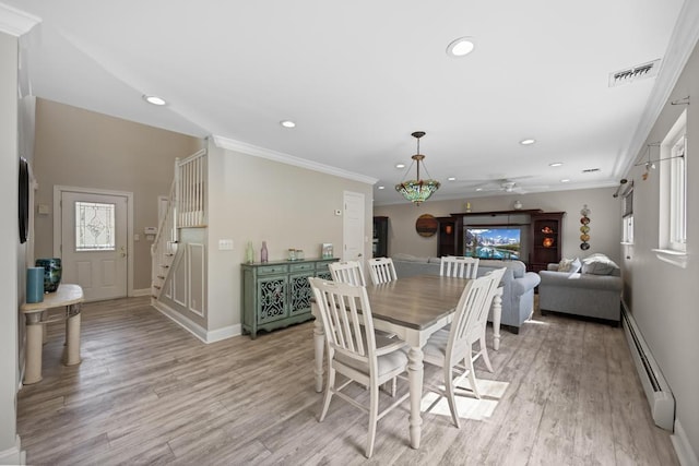 dining area featuring a ceiling fan, light wood-type flooring, baseboards, a baseboard heating unit, and stairs