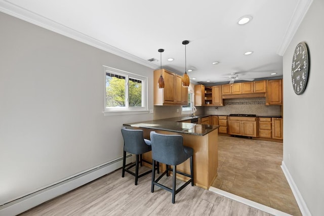 kitchen featuring tasteful backsplash, a sink, a baseboard heating unit, a peninsula, and ornamental molding
