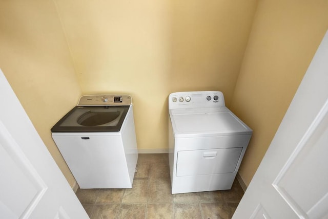 washroom with separate washer and dryer, laundry area, and baseboards