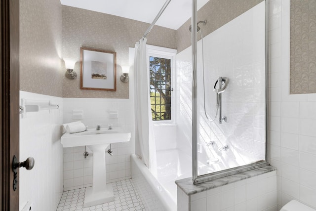 bathroom featuring tile walls, wainscoting, and wallpapered walls