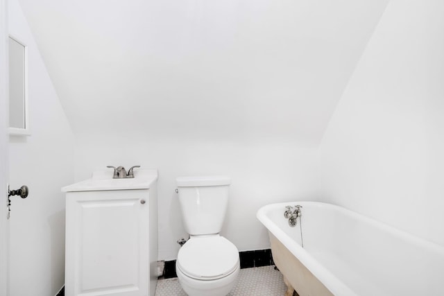 bathroom featuring vanity, vaulted ceiling, toilet, and a soaking tub