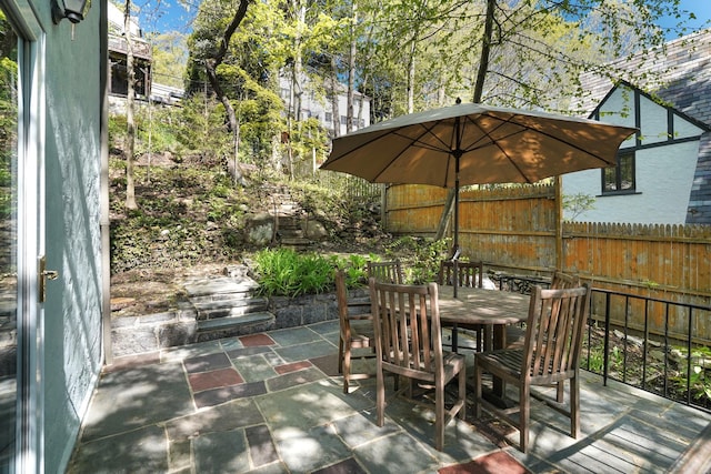 view of patio with outdoor dining area and fence