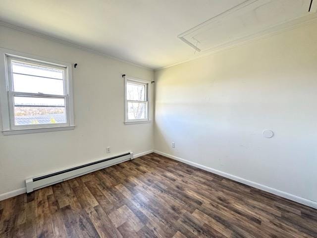 spare room featuring attic access, wood finished floors, baseboards, a baseboard heating unit, and ornamental molding