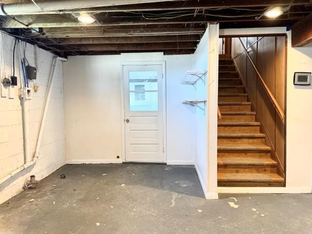 below grade area with stairs and concrete block wall